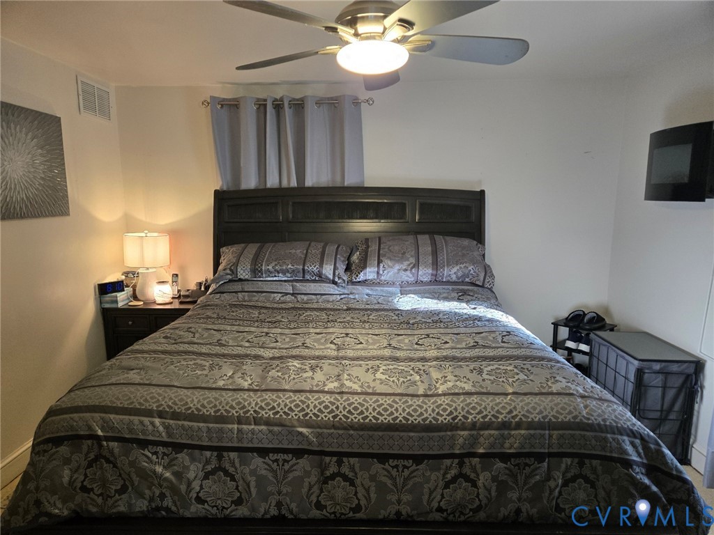 6883 Flat Rock Road Warfield, VA 23889 - Photo 8 of 25 a bedroom with a bed and a chandelier
