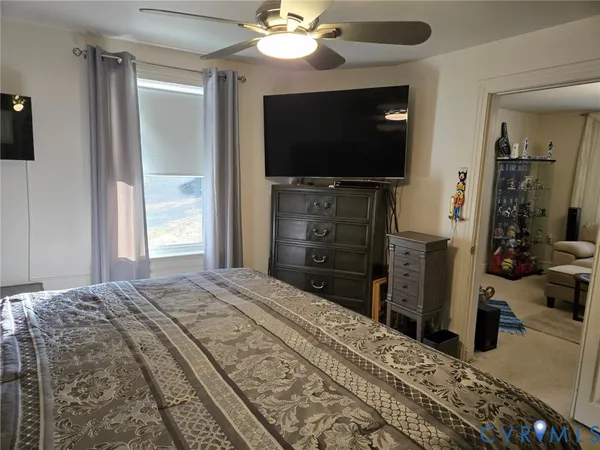 a bedroom with a bed and a flat tv screen on dresser
