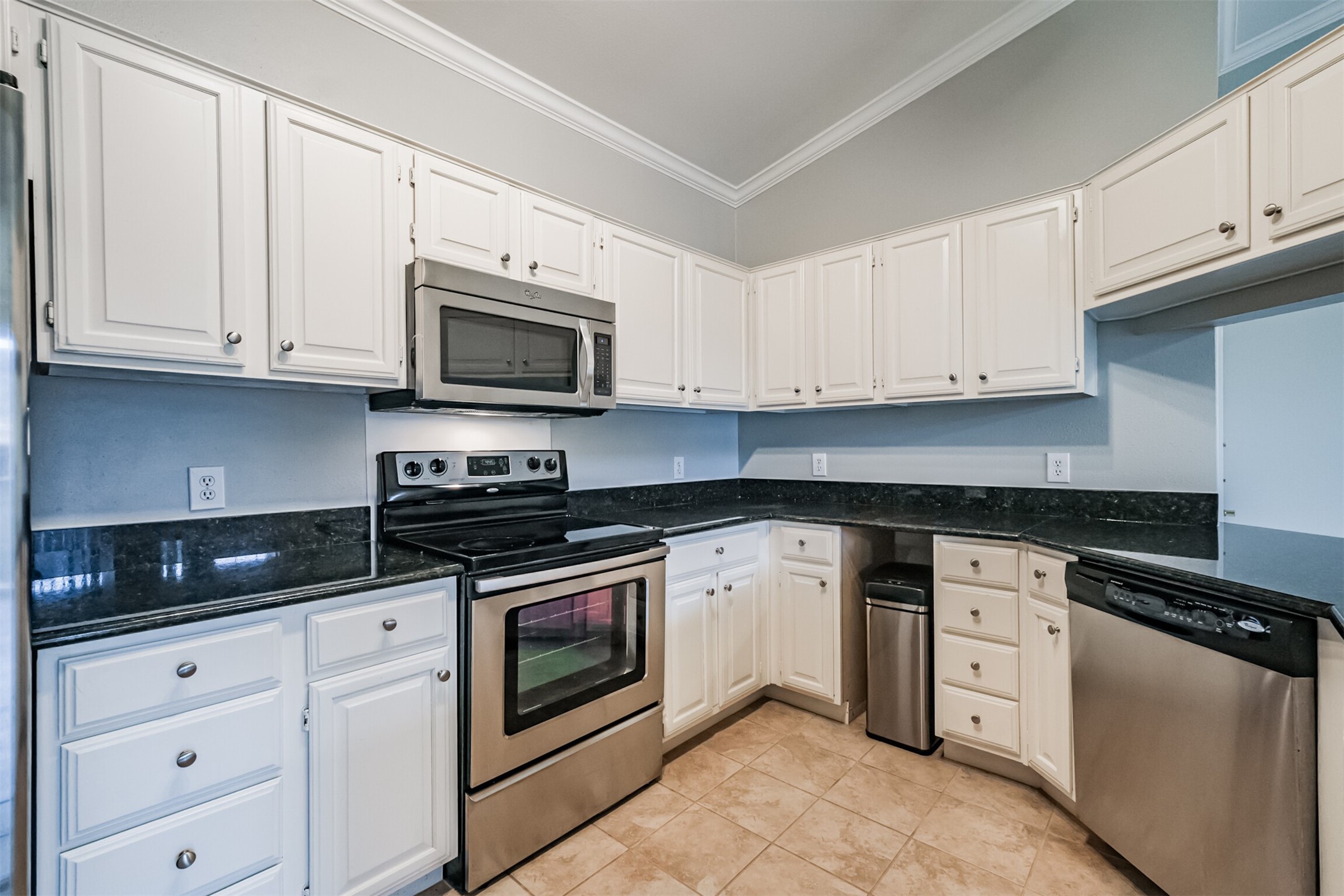 2111 Welch Street, Unit B304 Houston, TX 77019 - Photo 9 of 37 a kitchen with granite countertop white cabinets and stainless steel appliances