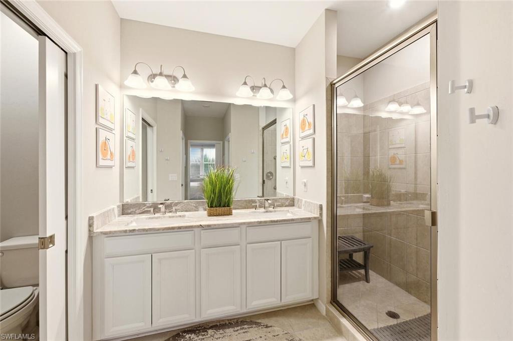 9365 Pocida Court, Unit 202 Naples, FL 34119 - Photo 21 of 40 a bathroom with a double vanity sink mirror and shower