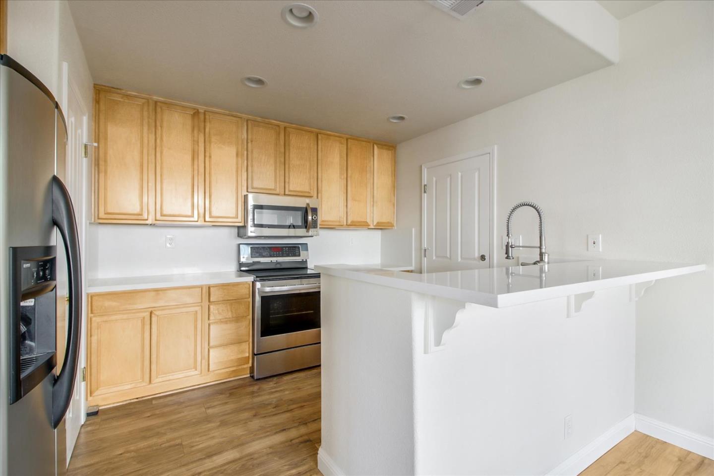82 Cannery Circle Campbell, CA 95008 - Photo 11 of 35 a kitchen with stainless steel appliances granite countertop a sink a stove a refrigerator with grey cabinets