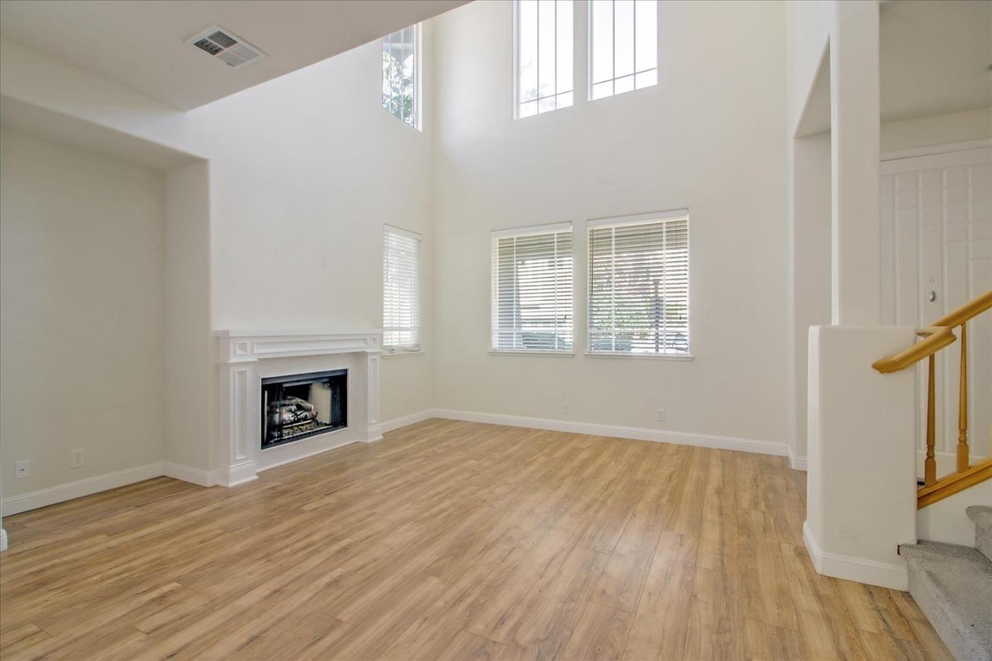 82 Cannery Circle Campbell, CA 95008 - Photo 5 of 35 an empty room with windows a fireplace and wooden floor