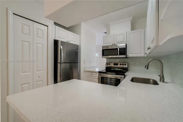 a kitchen with granite countertop a refrigerator stove and microwave