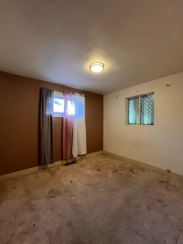 an empty room with windows and mirror