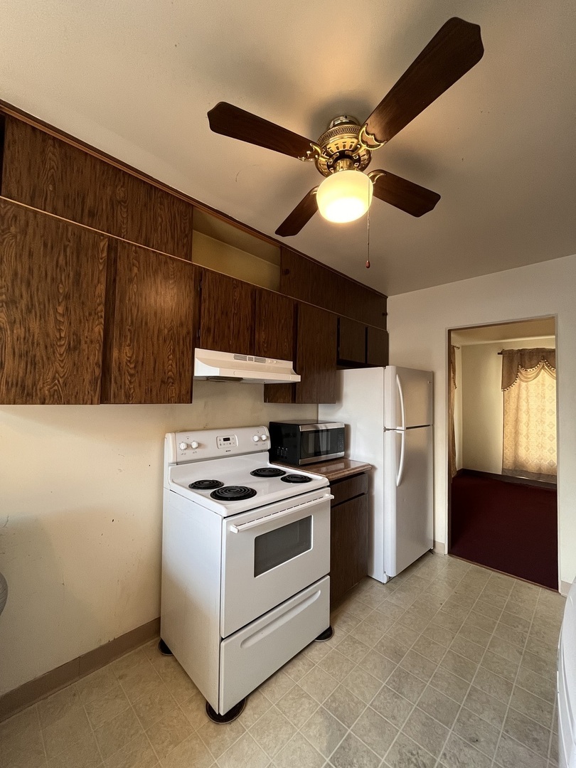 17218 Park Avenue Lansing, IL 60438 - Photo 5 of 19 a kitchen with stainless steel appliances granite countertop a sink a stove and a refrigerator