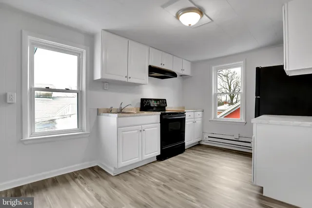 a kitchen with a refrigerator and a stove top oven