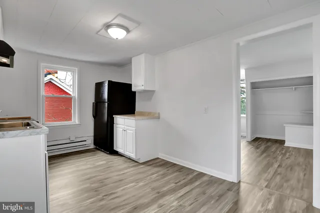 a view of a livingroom with wooden floor and a flat screen tv
