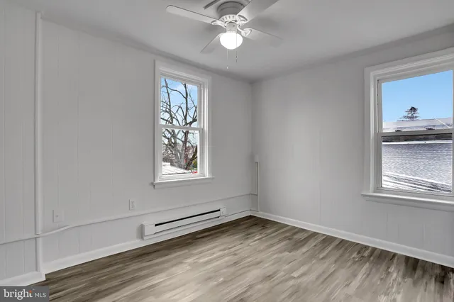 a view of a livingroom with a window and wooden floor
