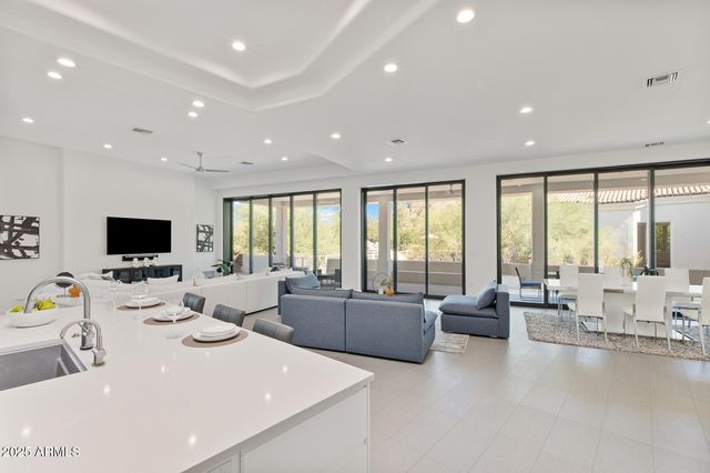 a living room with furniture a flat screen tv and a large window