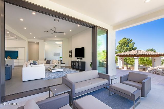 a living room with furniture a flat screen tv and a large window