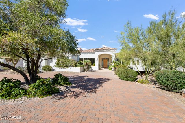 a front view of a house with a yard and potted plants