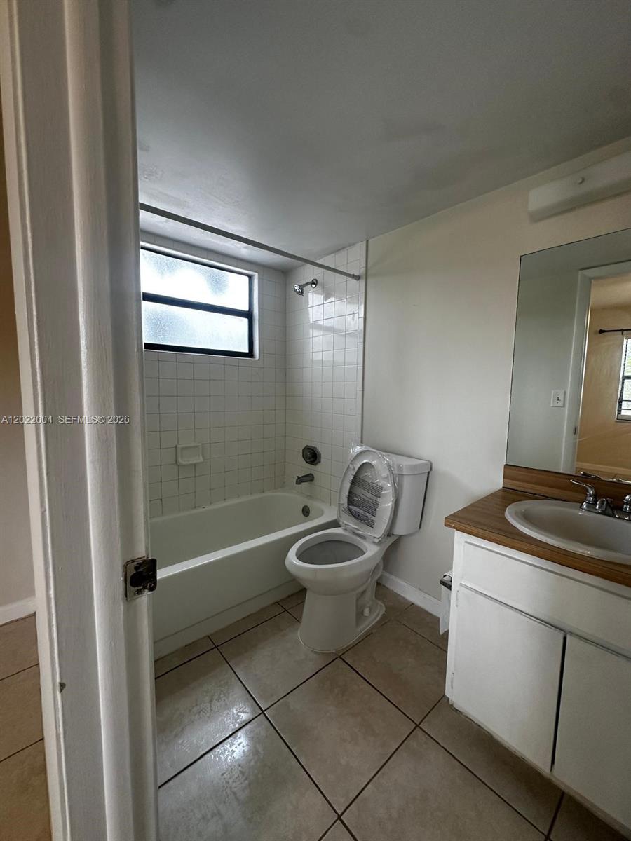 3400 Foxcroft Road, Unit 301 Miramar, FL 33025 - Photo 48 of 72 a bathroom with a granite countertop toilet a sink and bathtub