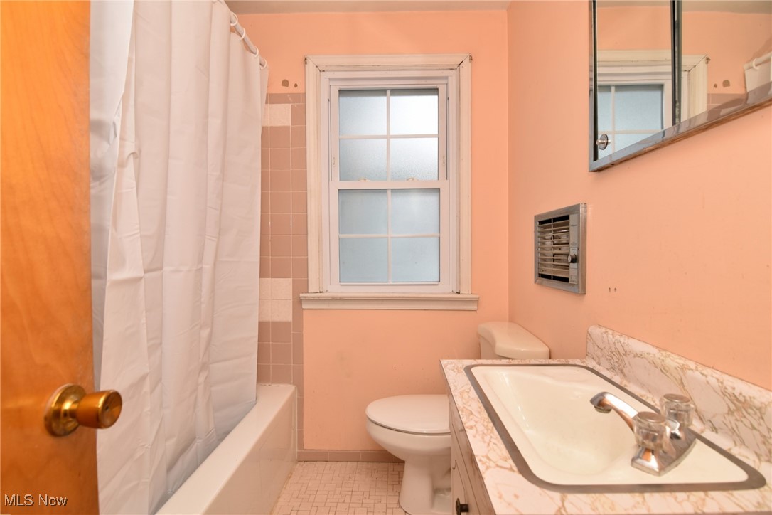 6308 Highland Road Cleveland, OH 44143 - Photo 32 of 40 Bathroom with heating unit, toilet, shower / bath combo with shower curtain, vanity, and tile patterned floors