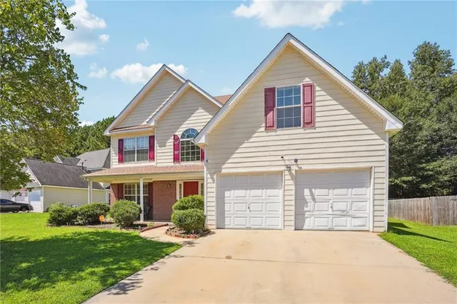 a front view of a house with a yard and garage
