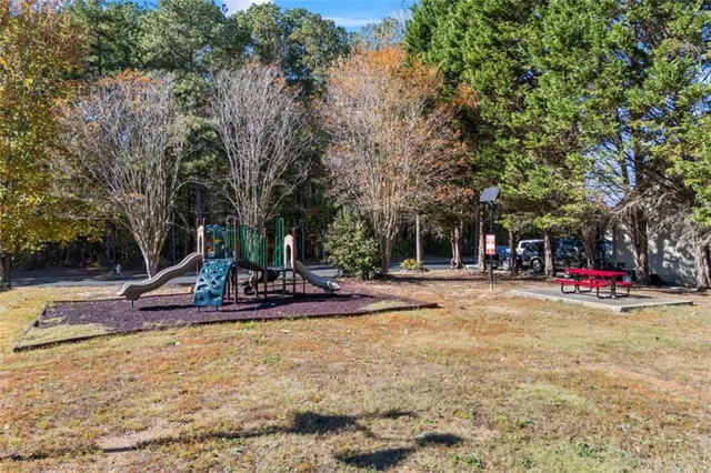 a view of a swimming pool with a bench and trees
