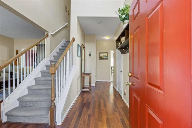 a view of a hallway with wooden floor and staircase