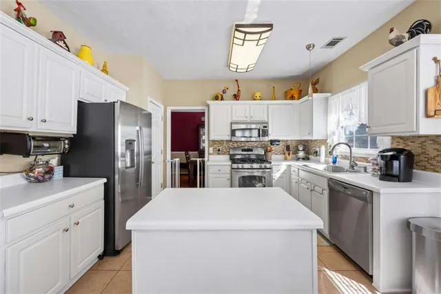 a kitchen with a sink a refrigerator a stove and cabinets