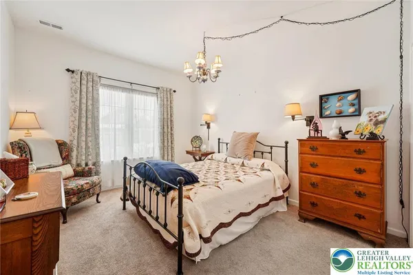 a spacious bedroom with a bed a couch and dresser