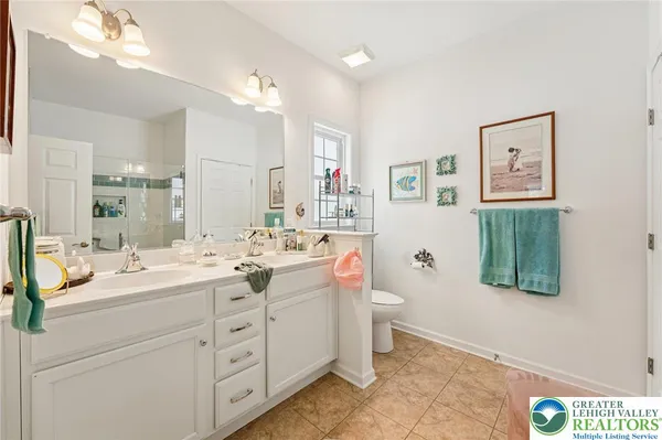 a spacious bathroom with a double vanity sink mirror and toilet