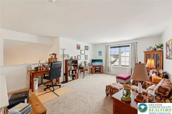 a living room with furniture a window and gym equipment