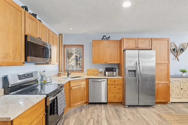 a kitchen with stainless steel appliances a stove refrigerator sink and microwave