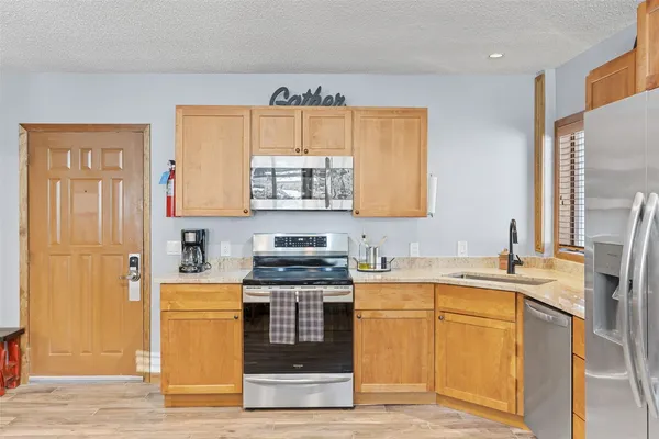 a kitchen with stainless steel appliances a sink stove and cabinets