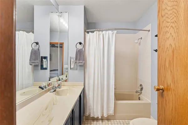a bathroom with a bathtub shower sink vanity and a mirror