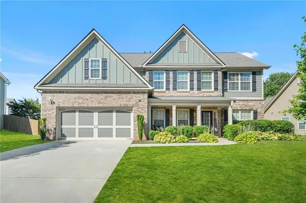 a front view of a house with a garden and plants