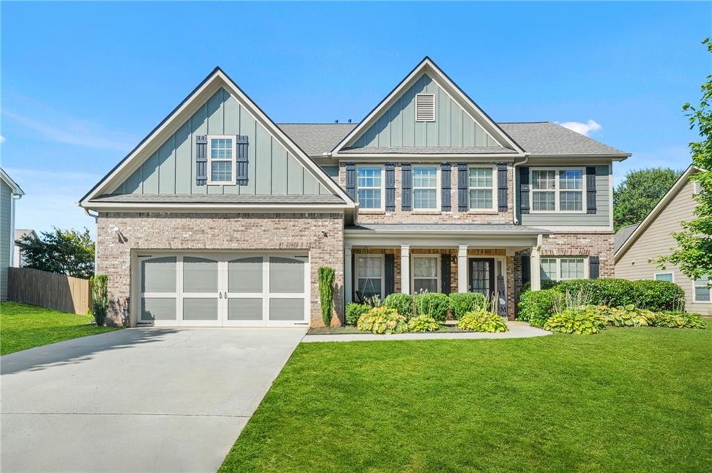a front view of a house with a garden and plants