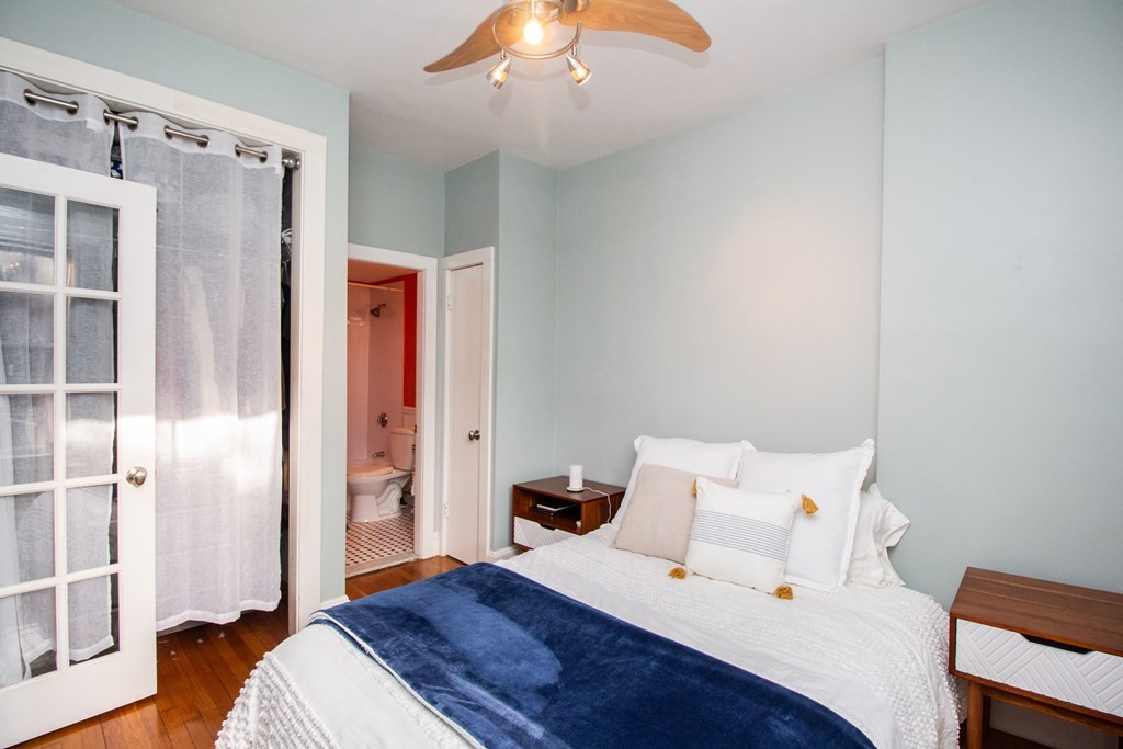 34 Winchester Street, Unit 2 Brookline, MA 02446 - Photo 10 of 14 a bedroom with a bed and a chandelier