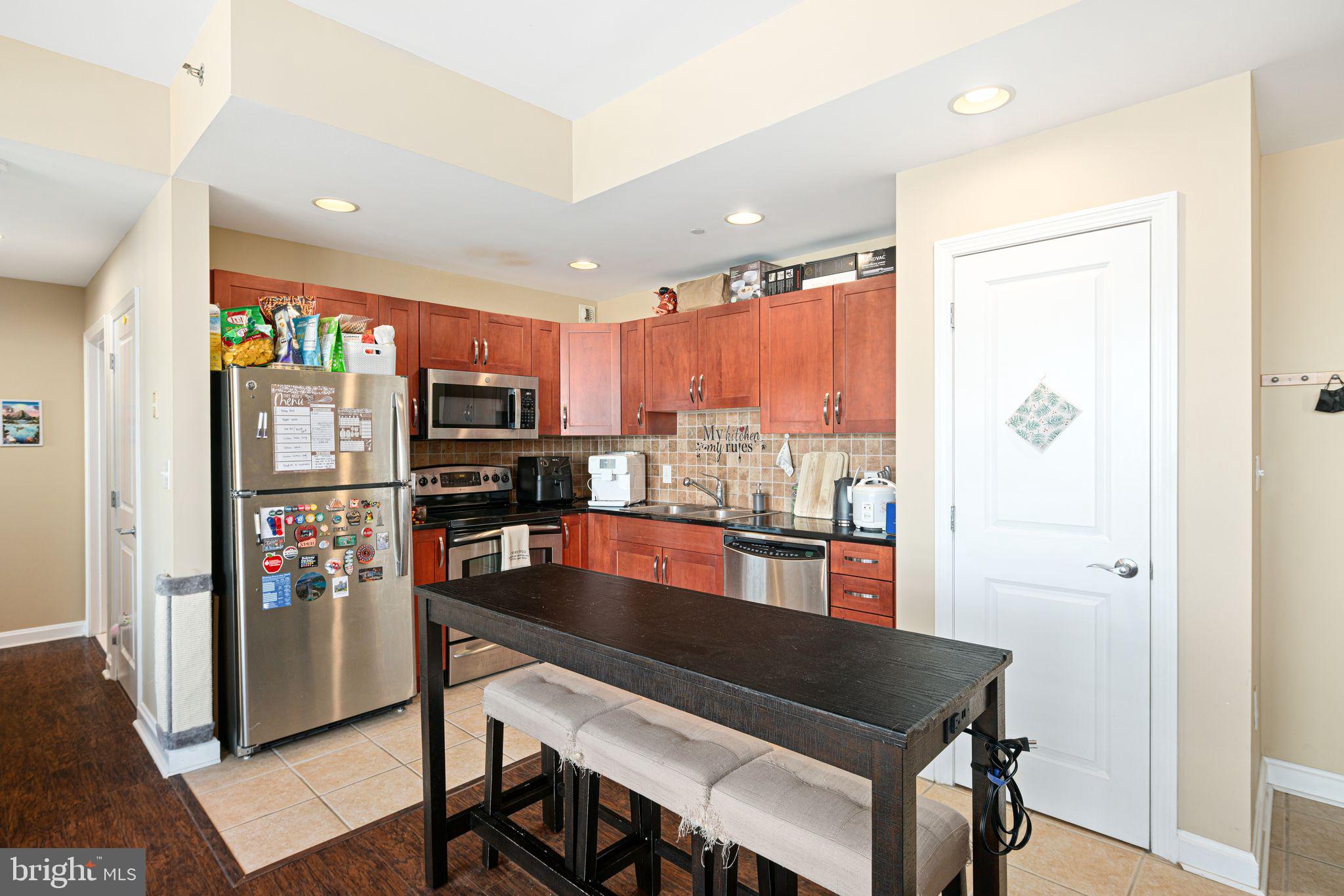 901 North Penn Street, Unit R507 Philadelphia, PA 19123 - Photo 3 of 28 a kitchen with stainless steel appliances granite countertop a refrigerator and a stove top oven