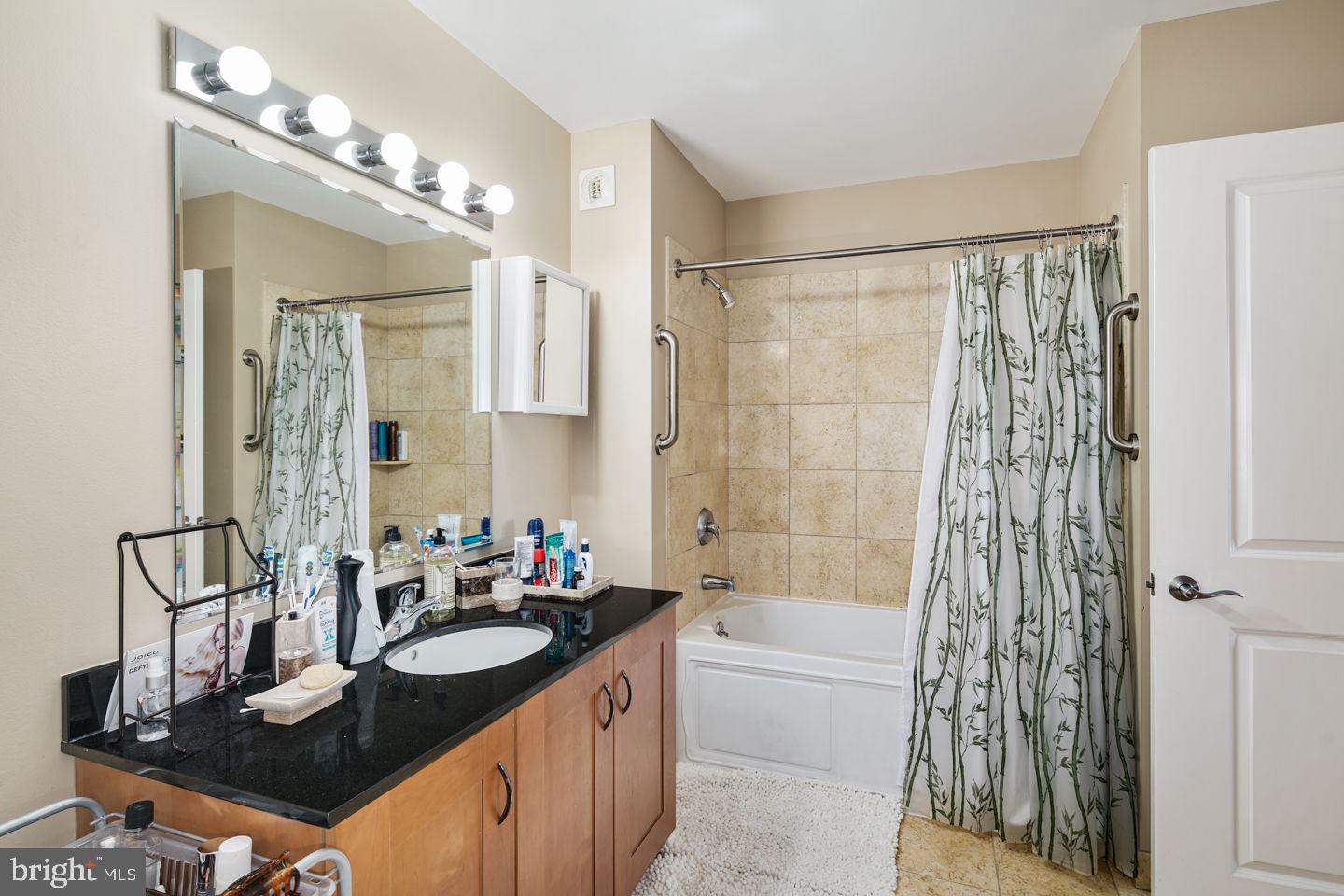 901 North Penn Street, Unit R507 Philadelphia, PA 19123 - Photo 7 of 28 a bathroom with a granite countertop sink a toilet a mirror a vanity and shower