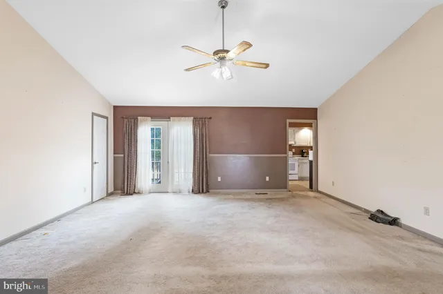 a view of a livingroom with a ceiling fan and window
