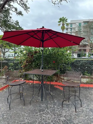 a view of yard with table and chairs under an umbrella