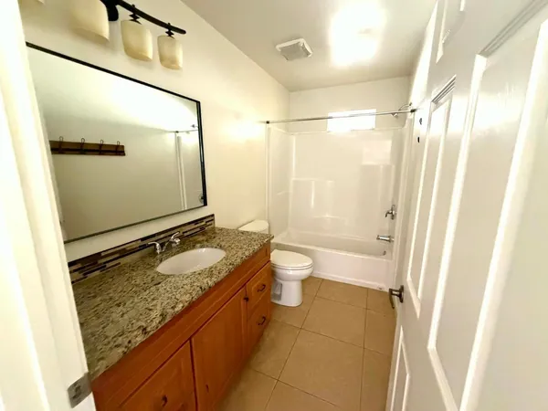 a bathroom with a granite countertop sink toilet and shower