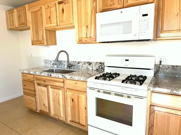 a white stove top oven sitting inside of a kitchen