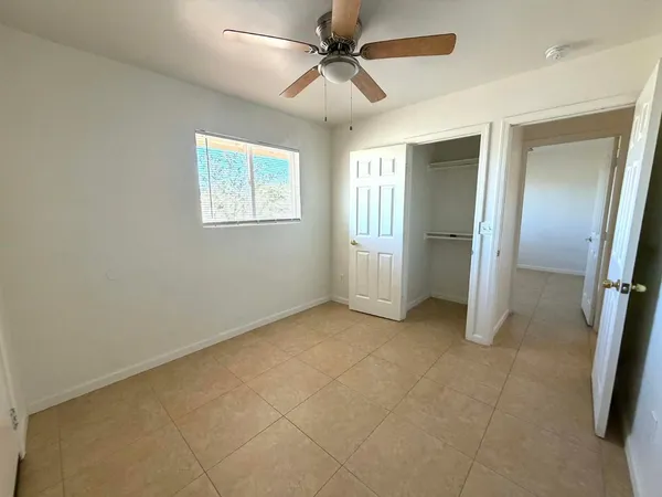 an empty room with fan and windows