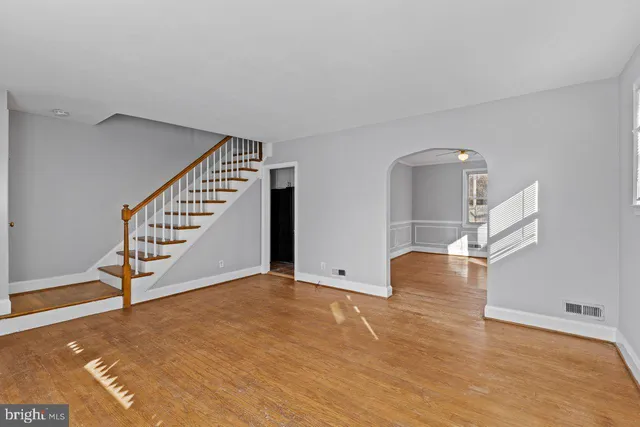 a view of empty room with wooden floor