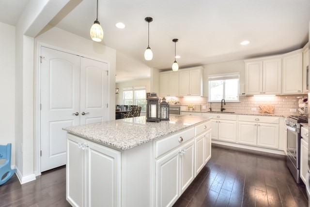 705 Kitty Hawk Road Georgetown, TX 78633 - Photo 9 of 21 a kitchen with stainless steel appliances granite countertop a sink cabinets and wooden floor