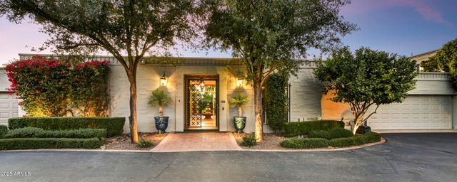 a front view of a house with a yard and potted plants