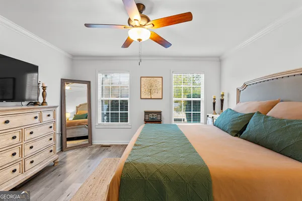 a bedroom with a large bed and a flat tv screen on dresser