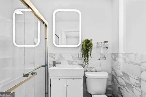 a bathroom with a toilet sink and mirror