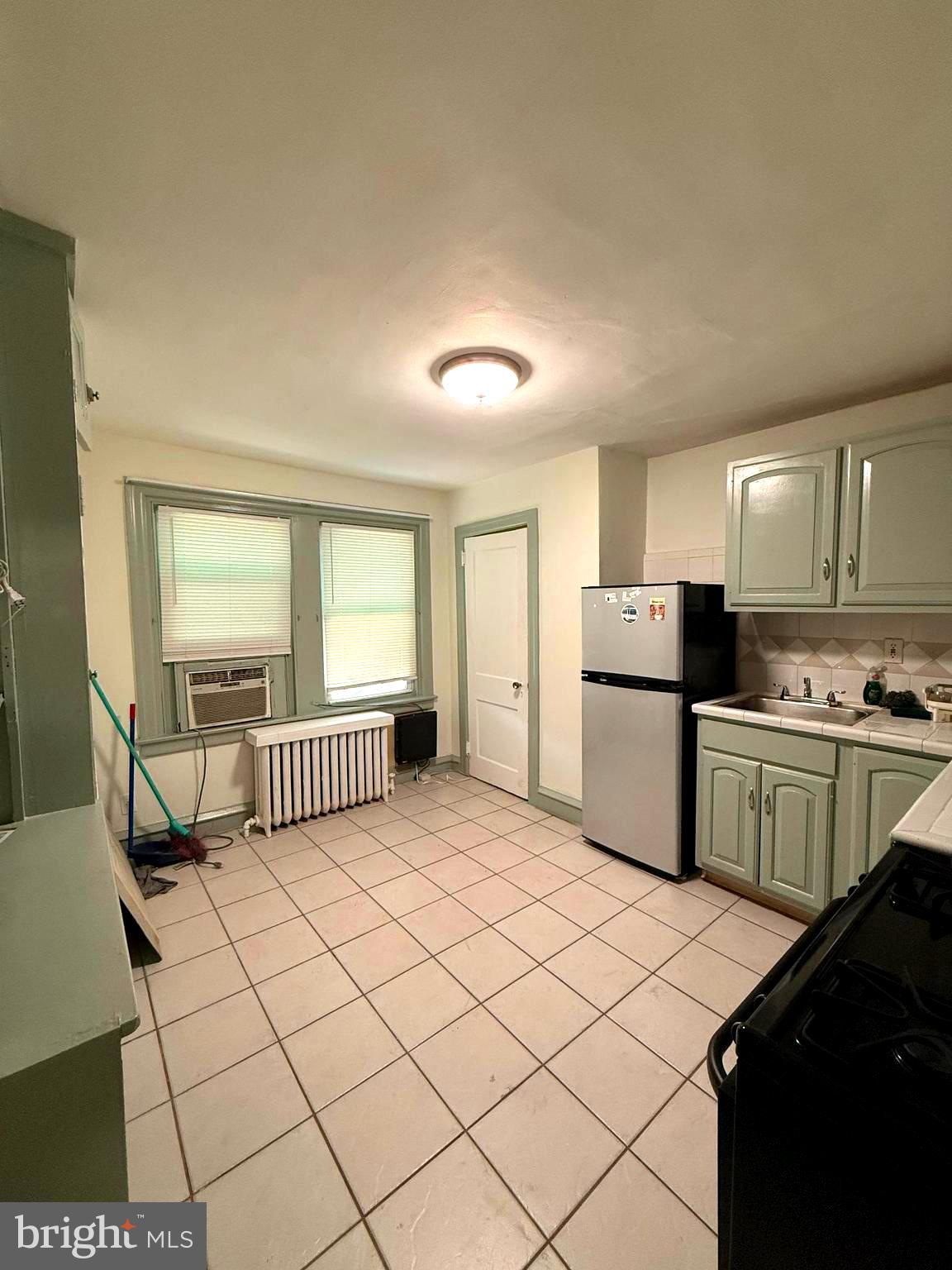 5118 Oakland Street, Unit 2 Philadelphia, PA 19124 - Photo 19 of 36 a kitchen with a refrigerator and white cabinets