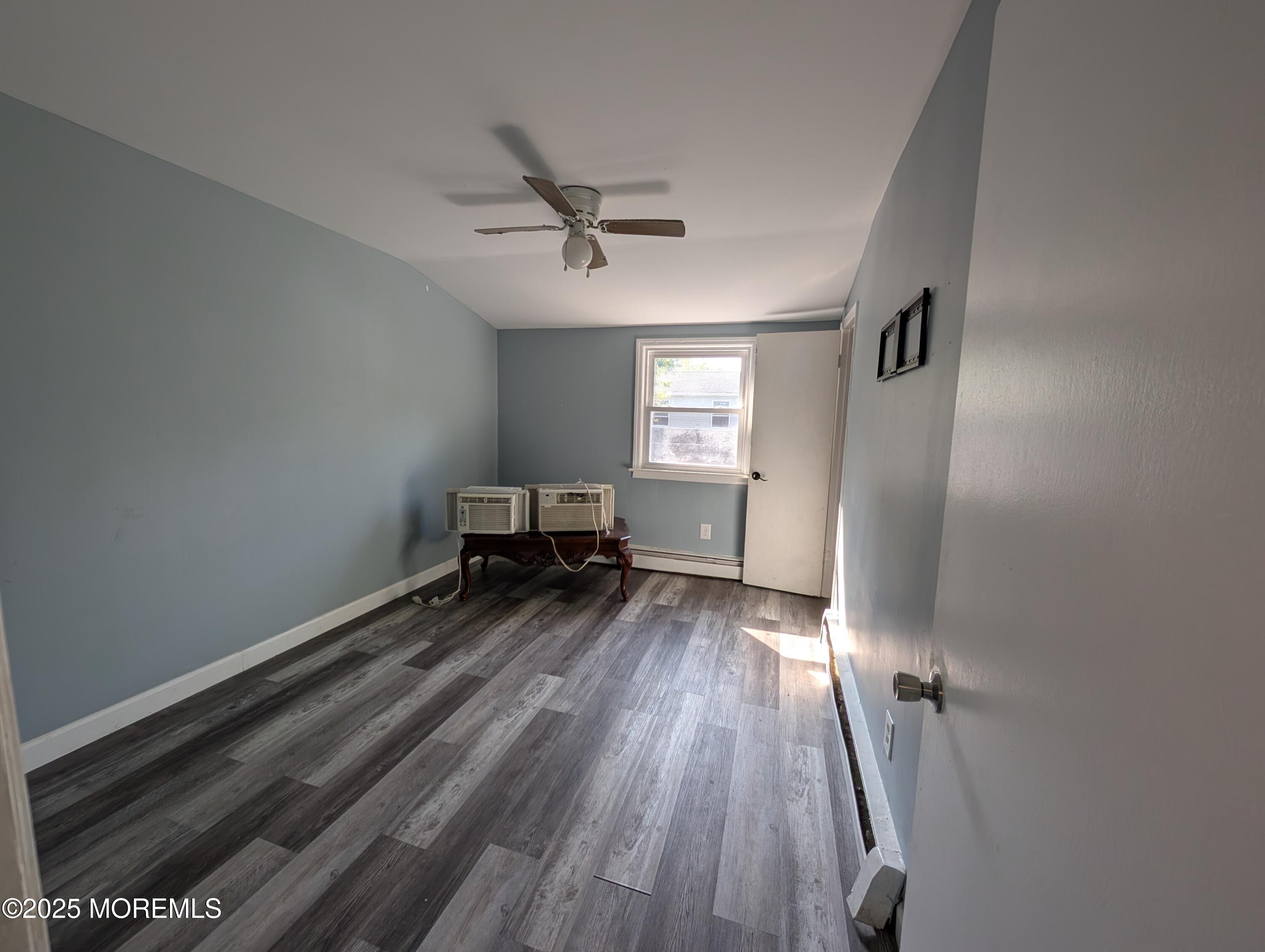 164 Port Monmouth Road, Unit B Keansburg, NJ 07734 - Photo 14 of 17 a view of a room with wooden floor a ceiling fan and windows