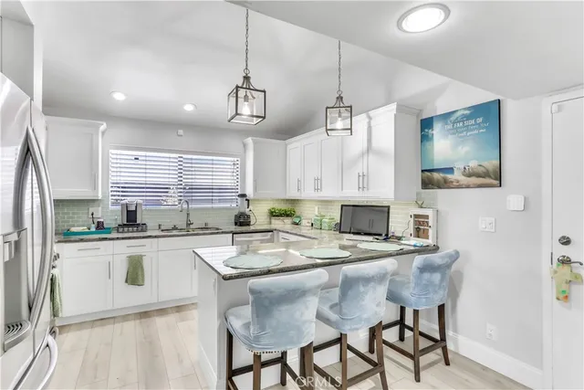 a kitchen with a table chairs refrigerator and cabinets