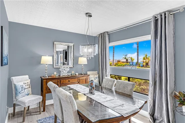 a view of a dining room with furniture a chandelier and wooden floor