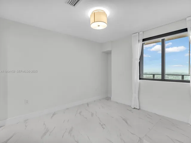 a view of a kitchen with white cabinets and a refrigerator