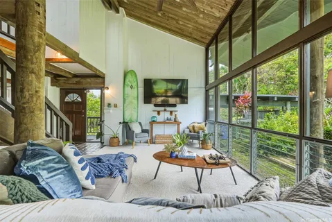 a living room with furniture tv and a floor to ceiling window