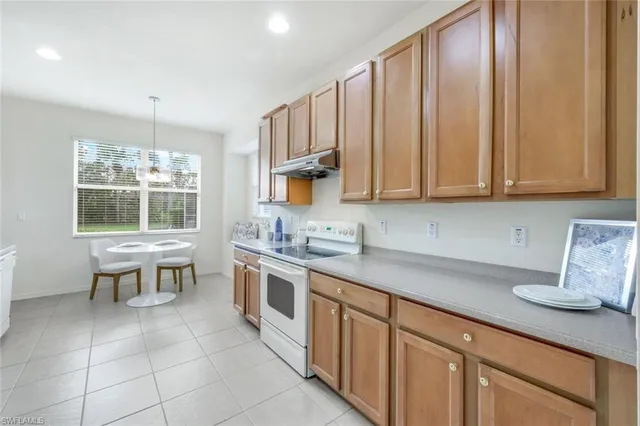a kitchen with stainless steel appliances kitchen island granite countertop a sink and a refrigerator