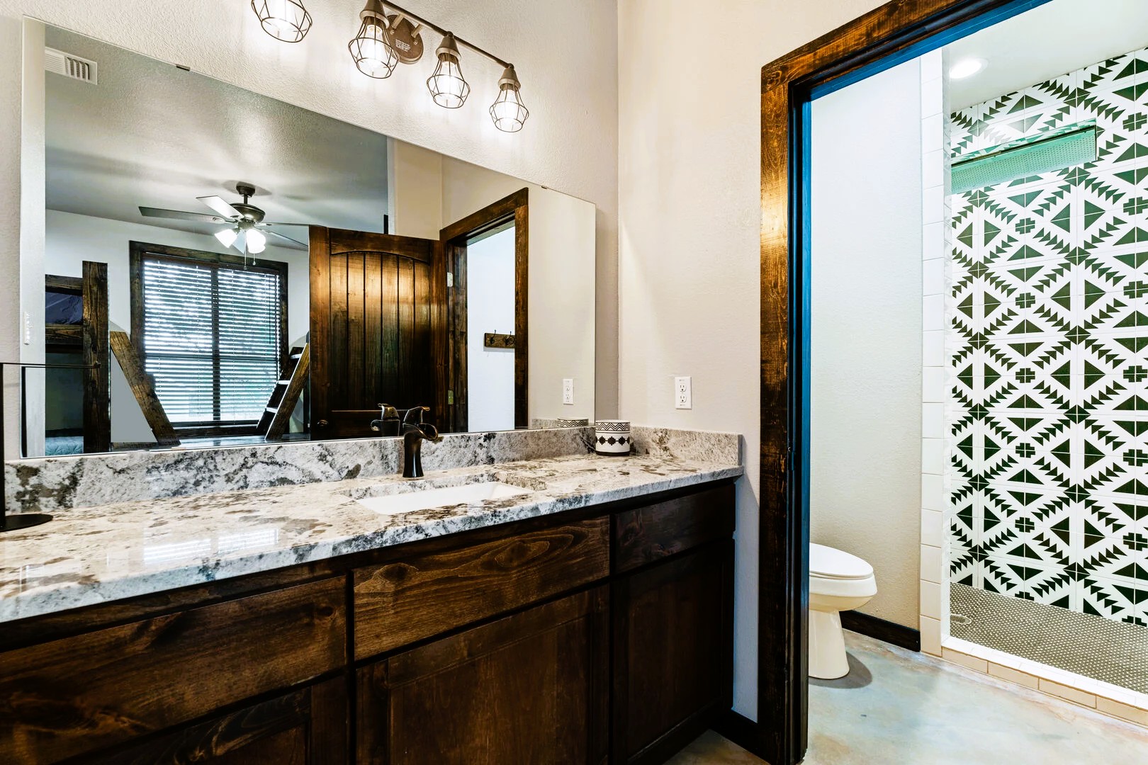 1718 Mountain Valley Road Concan, TX 78838 - Photo 20 of 40 Richly stained cabinetry and patterned tile work define this contemporary bathroom space.